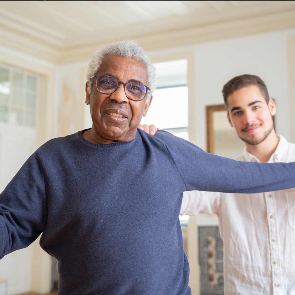 man being helped by a support worker to walk with confidence