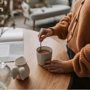 A lady staring a cup of tea on a table